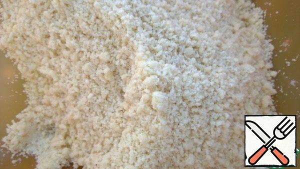 Sift the flour, mix it with baking powder. Cut the cooled butter into small cubes and mix with the flour. RUB to the state of crumbs.
