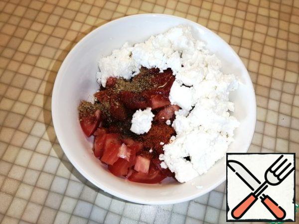 During this time, cut the tomatoes into cubes. Mix tomatoes, tomato paste, cottage cheese, vegetable oil, paprika, ground coriander in a deep bowl. Add salt and pepper to taste. Stir.