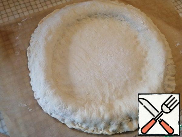 Roll out the second part of the dough in a circle of the same size and cover the pie. Pinch the edges well. Press down a little in the center with your hands.