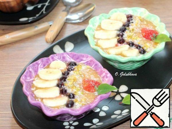 Pour the fruit puree into the bowls. Garnish the smoothie with berries, fruit, coconut shavings, nuts, and a mint leaf.