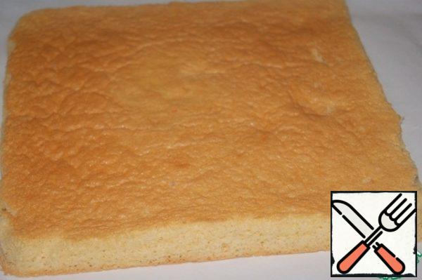 Remove the cooled biscuit from the paper on which it was baked and place it on a clean sheet of paper with the "sunburned" side up. Cover with a napkin and prepare a cream that will be applied to the "tanned" side.