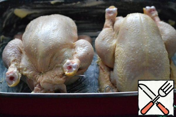 Fill the chicken with the filling. Secure the holes with a toothpick or skewers.
Grease the baking dish with oil.
Put the chickens in the form.
