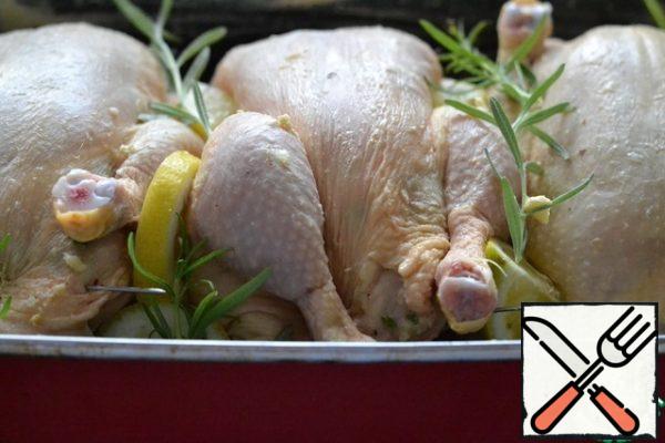 Spread the rosemary sprigs and lemon wedges between the chickens.
Bake the chickens in a preheated oven at 180g for 45-50 minutes.
Do not forget to water the chickens with juice that will stand out when baking. Increase the temperature to 200g and bake until Golden brown.