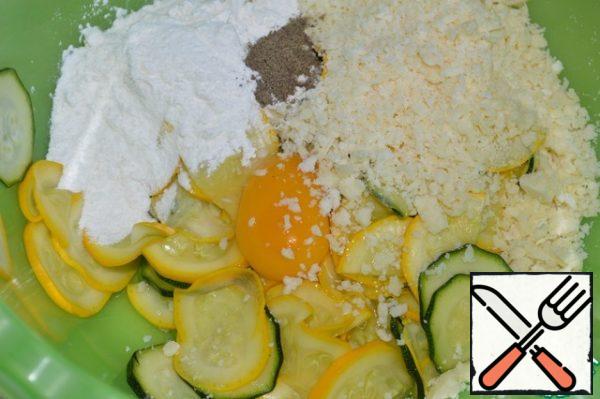 Pour the flour, grated Parmesan, and ground pepper into a bowl with the zucchini.
Add egg.