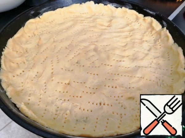 Sprinkle the baking sheet with flour and put the dough on the bottom, leaving a small side. On the cake to make punctures with a fork