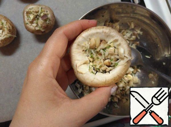 Add a little salt to the mushroom caps from the inside. Stuff with the filling, tightly tamping.