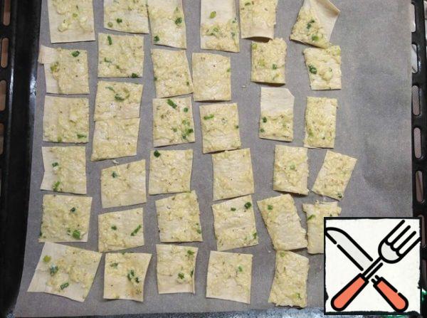 Cut the smeared pita bread into strips with food scissors, then into squares or triangles.