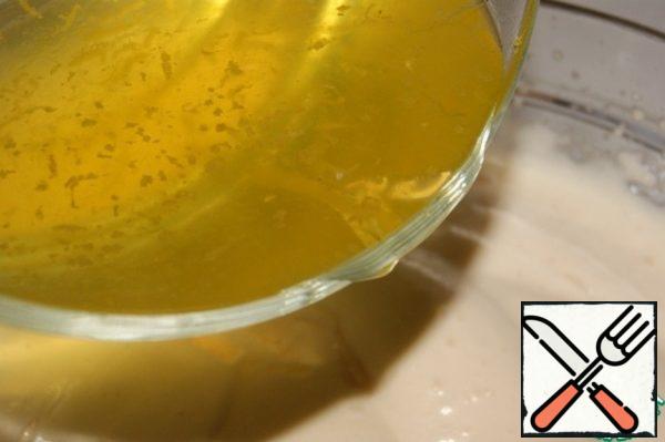 In a thin stream and stirring constantly with the spatula to introduce the jelly mixture.