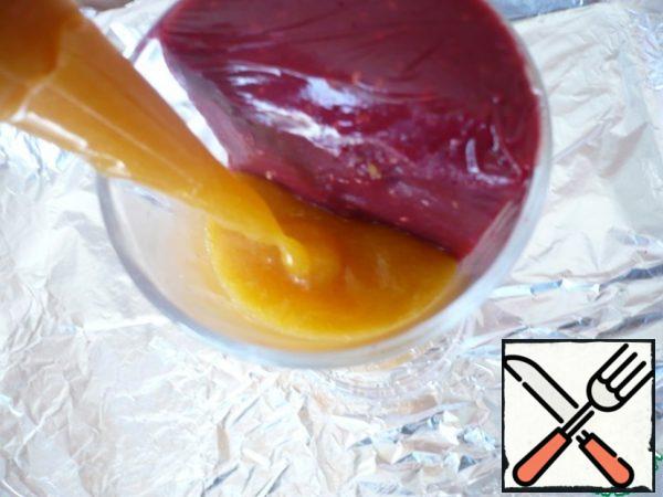 From the refrigerator, take out the molds with raspberry puree, which is completely frozen. Release the molds from the food film and start carefully filling the second half of the form with apricot puree, using a cooking bag.