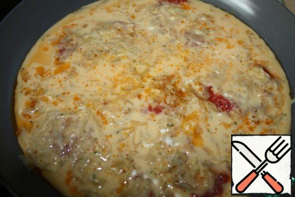 Then pour the egg mixture and simmer under the lid until the eggs are ready.
Then cover the pan with a plate and carefully turn it over.