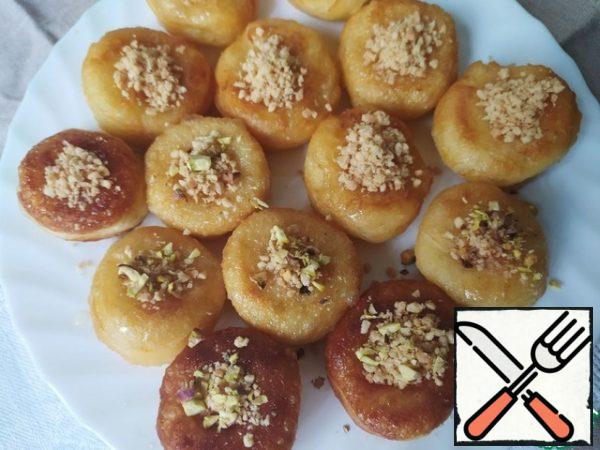 Chop the pistachios in any convenient way. Fill the holes in the doughnuts with crushed nuts.