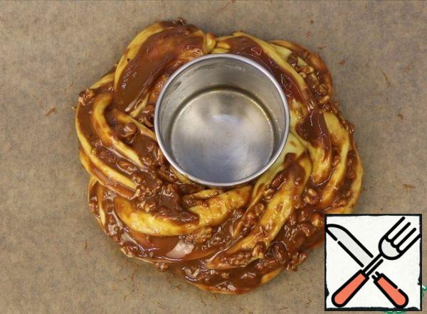 Carefully transfer to the baking tray. I bend the edges.
In the center, you can set some ring, so that the wicker during proofing does not lose its shape and does not float.
Cover with plastic wrap and put in a warm place for 60 minutes.