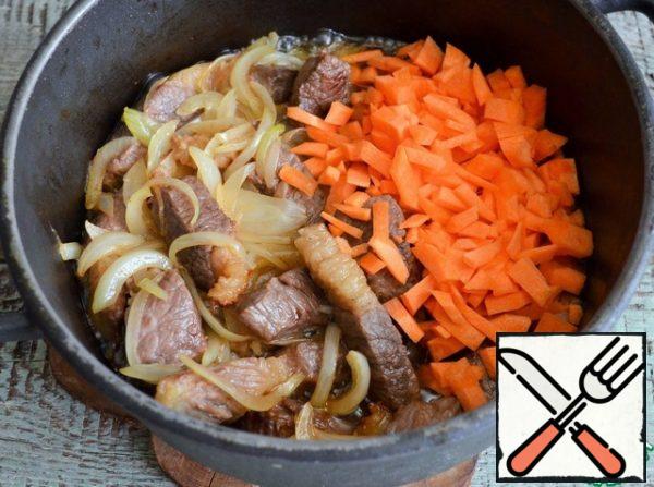 Add the onion to the fried meat, fry until transparent, medium heat, 5-7 minutes. Then add the carrots.