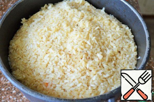 Cover with a lid and cook the pilaf over low heat for 20-25 minutes, until the liquid evaporates and the rice is ready.