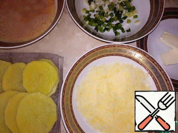 Ingredients for a hearty Breakfast are ready: egg filling: sliced thin slices, washed in cold water and dried with a napkin potatoes (do not keep long in the air); chopped green onions; grated on a medium grater hard cheese; 2 tablespoons of butter.