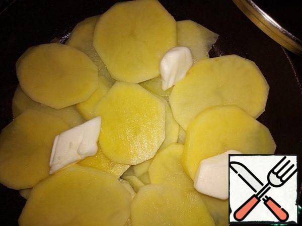 Spread the potato slices without gaps in one layer on the pan.
Top with a second tablespoon of butter.