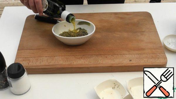Prepare the marinade. To do this, mix the chopped garlic, thyme and oregano in a separate bowl, then dilute with olive oil to a thick paste.