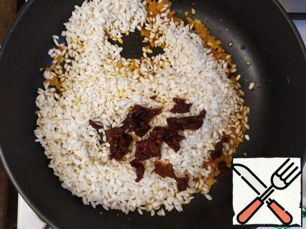 Add the rice, chopped tomatoes, mix and fry for five minutes.