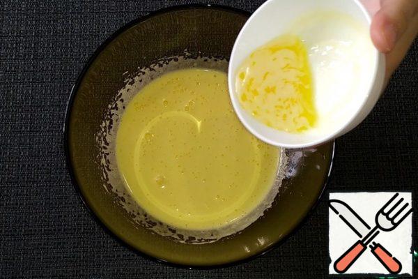 Add the melted butter to the beaten egg mass and mix gently.