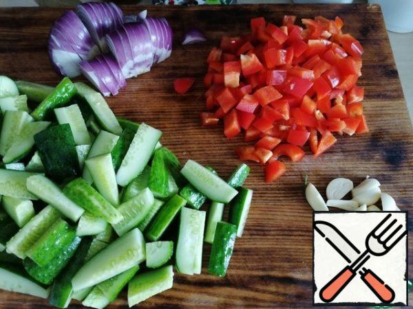 Prepare the jars in advance, steam them a little and dry them.
Wash the cucumbers and fill them with cold water. Wash the pepper, remove the partitions and seeds. Peel the onion and garlic. Garlic cloves cut in half, pepper cut into cubes, onion-small slices, cucumbers-small slices, also cut celery and parsley.