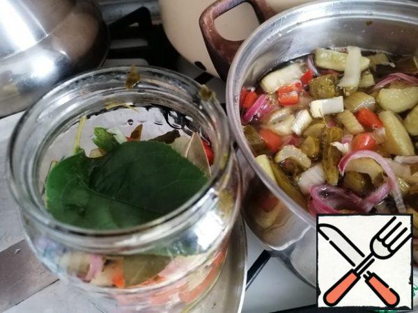 Remove the vegetables with a slotted spoon and arrange them in layers in the jars and lay the layers with currant and cherry leaves 1 PC.
If desired, you can add one Bay leaf.