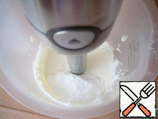 Whisk the cold cream with 3 tablespoons of powdered sugar on high speed.