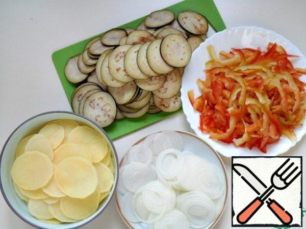 Peel onions, potatoes, eggplants, wash, dry, cut into thin rings, wash bell peppers, peel, divide into 4 parts and cut into thin strips.