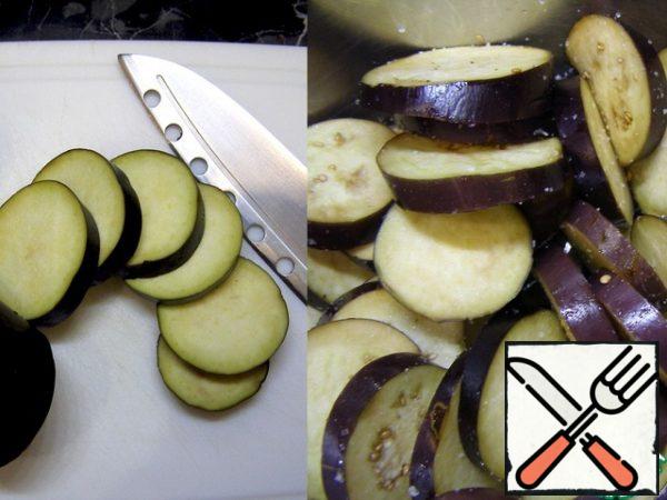 First, prepare the eggplants. Cut them into thin rings or half-rings, as you like. Add salt, mix and leave for 20 minutes.