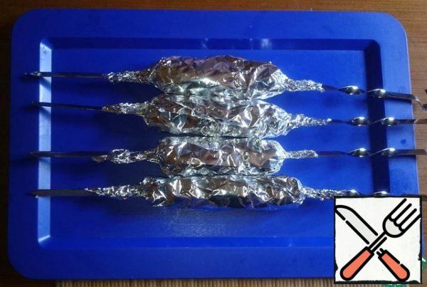 Put the skewer with potatoes on the foil, sprinkle with garlic and wrap.
Who likes - can add any herbs. Rosemary, Provencal, etc.