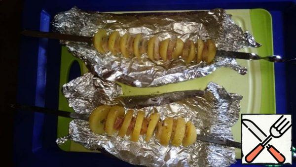 Remove the potatoes from the fire, carefully unfold. It's almost ready.