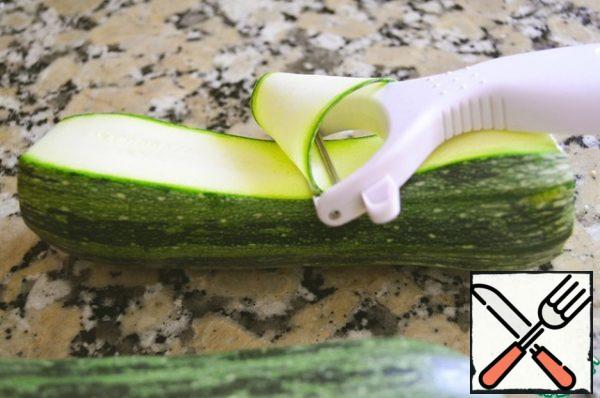 Cut the zucchini into thin strips using a mandolin (vegetable cutter) or peeler and place in a large bowl.