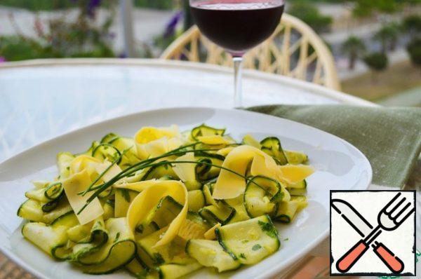 Spread the marinated zucchini on plates, sprinkle with Parmesan shavings and garnish with chives.