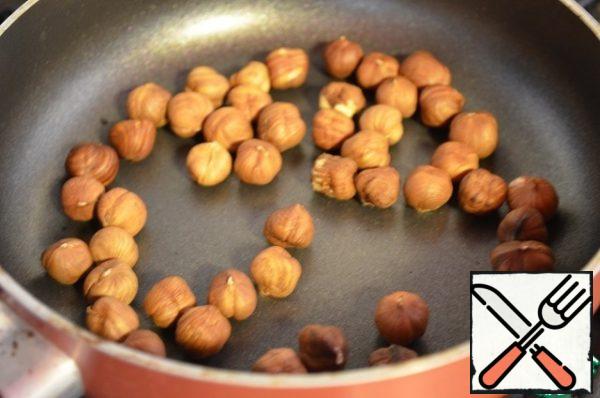 Fry the nuts in a frying pan. Mix all the ingredients in a bowl and arrange on plates. Top with melted chocolate.