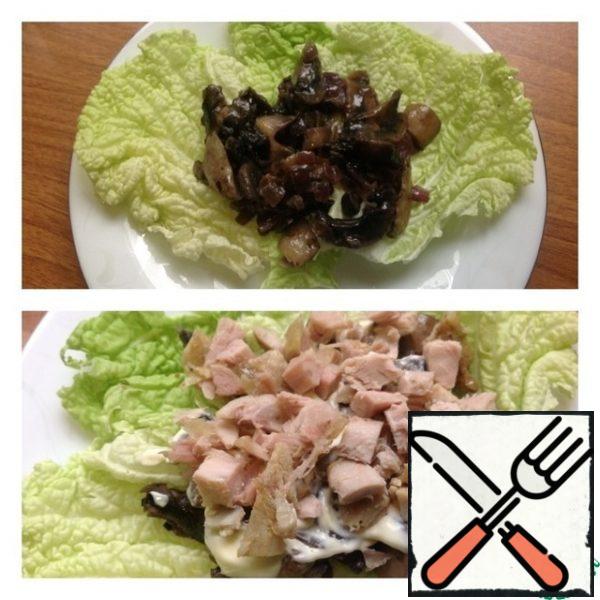 On a high heat in a frying pan in oil, fry the mushrooms cut into plates and finely chopped onions. A little salt and pepper. On the lettuce leaves, spread the cooled mushrooms with onions. Then a layer of mayonnaise or sour cream. Who likes it. Next, a layer of boiled chicken breast, cut into small cubes.