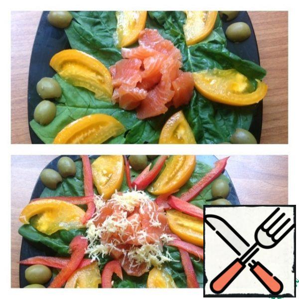 Cut the salmon into thin and small slices, and place in the center of the plate. Bulgarian pepper is very thinly cut into strips and spread to the salad.
Three cheeses on the smallest grater and sprinkle on top of the salmon. Making salad dressing. In a bowl, mix sour cream or mayonnaise, add salt, pepper, Ideal oil and garlic passed through the press. Mix and water the fish.