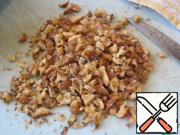 Meanwhile, heat the walnuts a little in a dry pan and chop them.