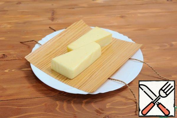 1. Preheat oven or barbecue (for indirect cooking) to 160-180 ºC.
2. Submerge the grill paper and string in water, wine, beer or juice for 10-40 minutes.
3. Grease the front of the grill paper with oil and place the cheese in the middle of the sheet along the grain of the wood.  Drizzle with oil on top, add some salt and black pepper.