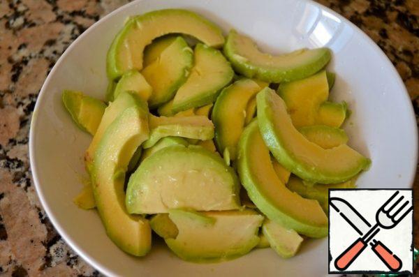 4. Peel the avocado, cut into slices of medium thickness and pour generously with lemon juice.