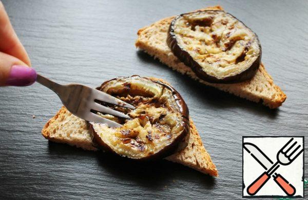 Toast bread cut into corners. Spread a thin layer of cottage cheese sauce. Put the eggplant on top and lightly crush it with a fork.
