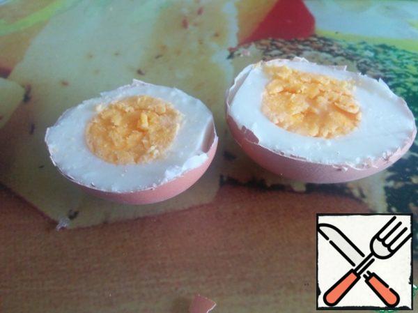 Hard-boiled eggs, cool. With a sharp knife, cut them in half, trying not to damage the shell.