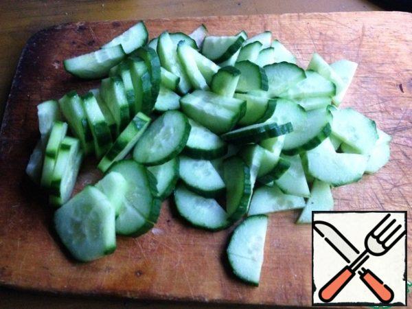 Wash cucumbers, dry, cut into semicircles.