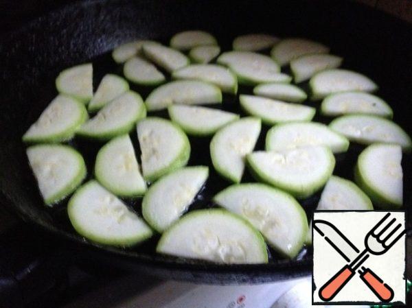 Wash the zucchini, dry, cut into half circles and fry in a little olive oil.