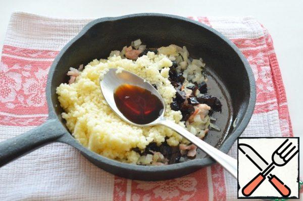 Mix the ready-made couscous, fried onions with bacon, and prunes. Add soy sauce to taste and stir.