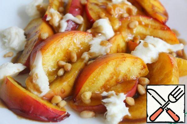 Add the mozzarella.
Mix 2 tbsp olive oil with balsamic, honey and a pinch of mustard powder, beat well and pour over the peaches.
Sprinkle with pine nuts.