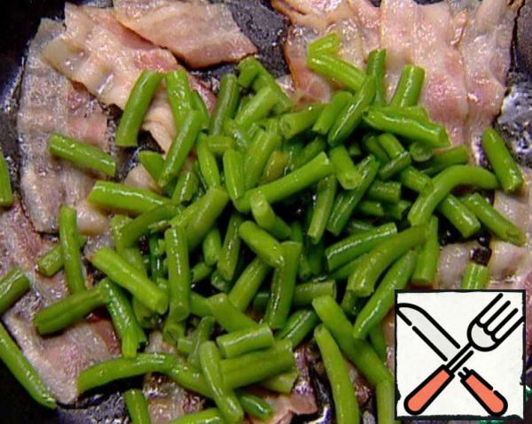 Pour in a little olive oil and add the pre-boiled string beans.