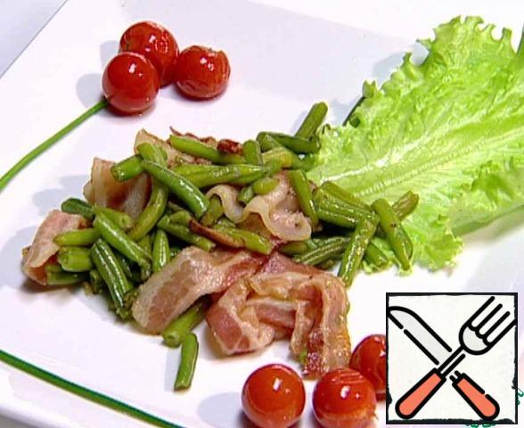 Cover the plate with a lettuce leaf, put the finished beans. Garnish the dish with roasted cherry tomatoes and chives.