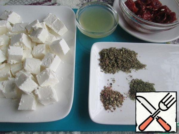Cut the cheese into cubes.
Squeeze the juice out of the lemon.
Prepare the sun-dried tomatoes, Basil, thyme and pepper mixture. Dried herbs can be taken to your liking.