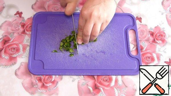 Prepare the marinade.
Finely chop the dill and parsley.
We send it to a bowl.