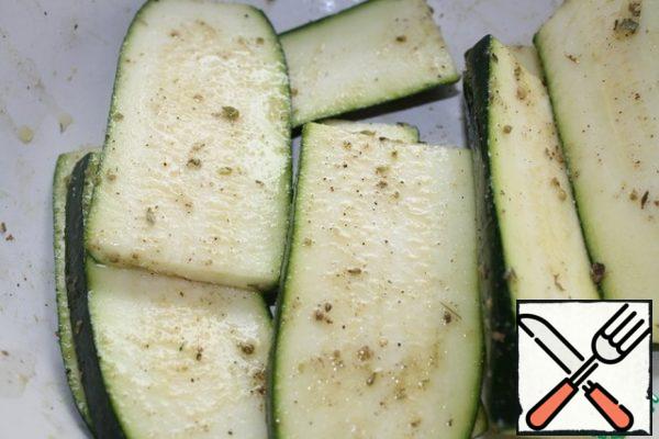 Cut the zucchini into plates, or if it is large, then with washers.
Season with salt, pepper, sprinkle with your favorite herbs and drizzle with oil.
I also add garlic powder, but you can finely chop the fresh one.
Let marinate for about 20 minutes.
