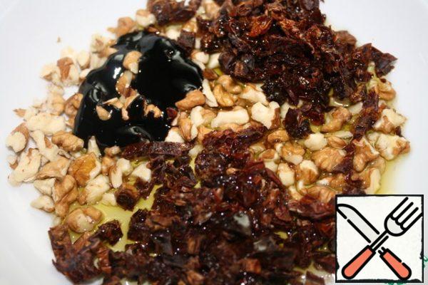 Break the nuts finely.  Finely chop the dried tomato too.
Mix everything with oil and balsamic, and let stand for 20 minutes.
If the entire mixture is not used, then transfer the leftovers to a jar and store in the refrigerator.
